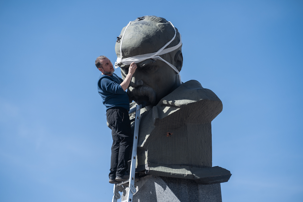 A man is bandaging a head of the monument
