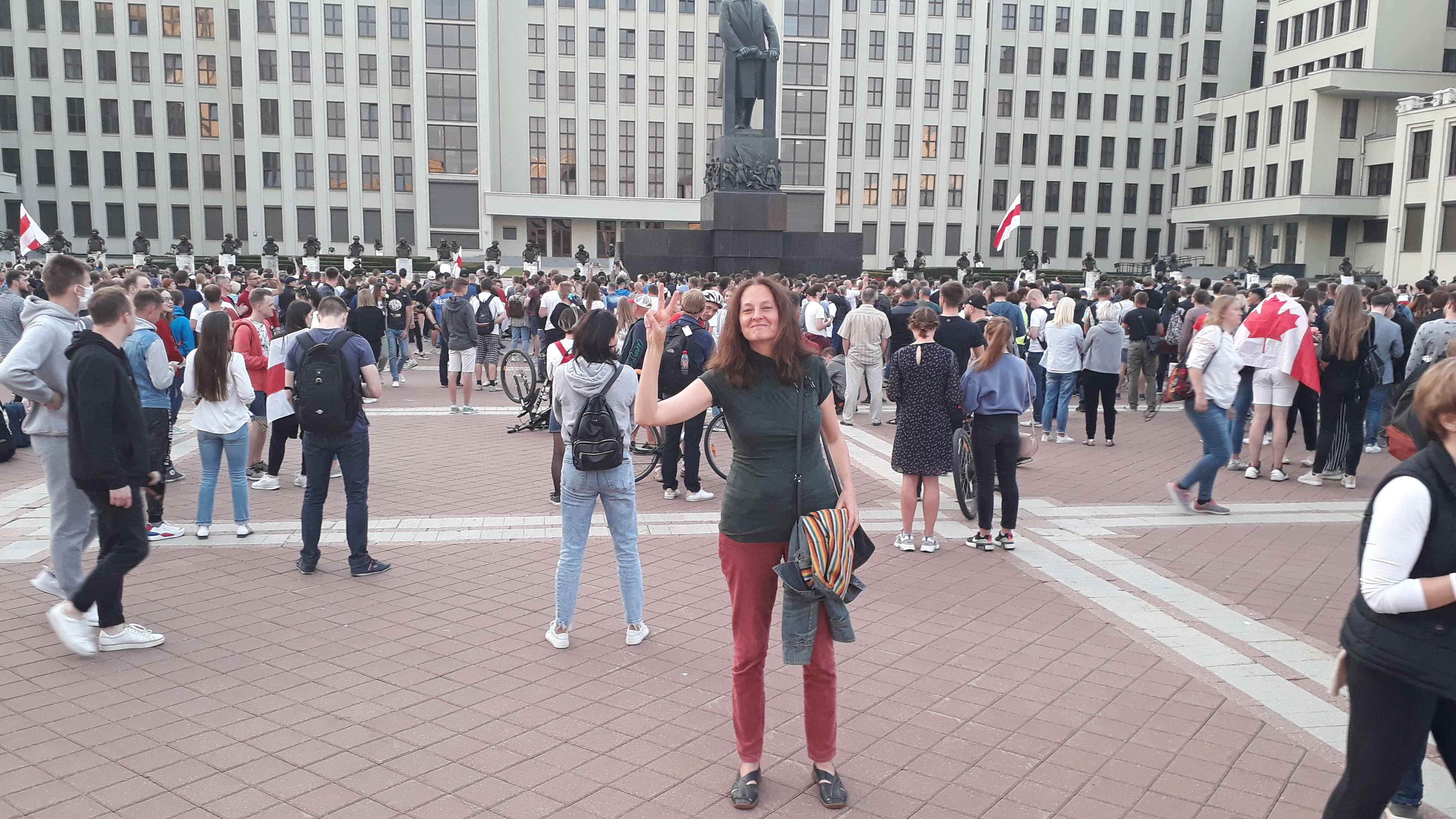 14 August 2020 in Minsk, standing in the square the author holds up a peace sign.