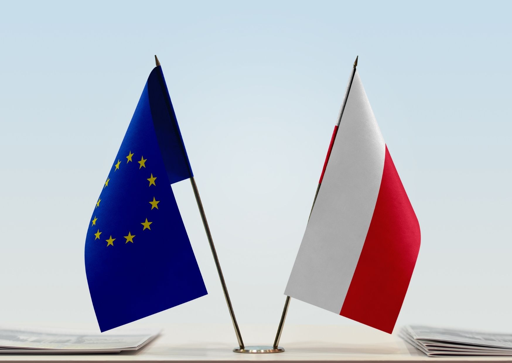 EU and polish table flags side by side on a desk