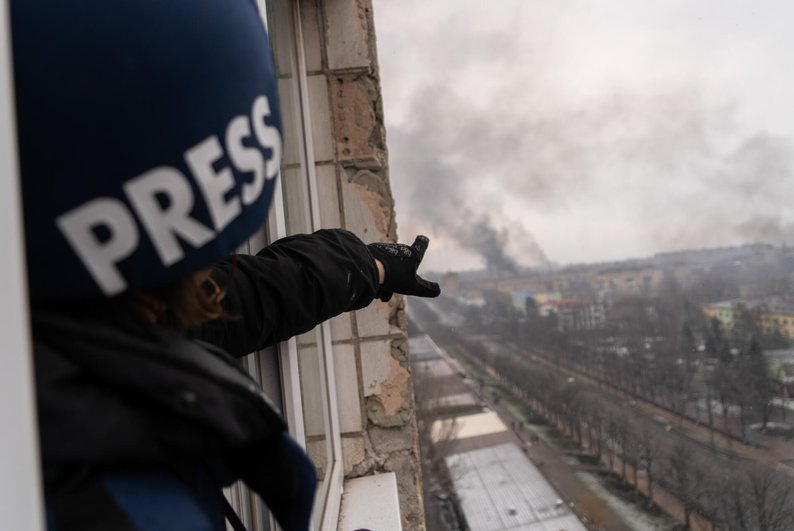 "A Reporter Pointing at an Explosion"