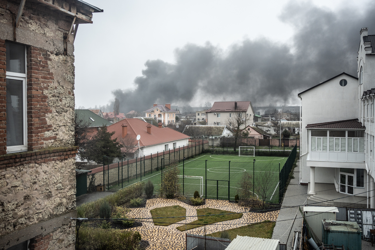 A smoke from shelling over the houses and a football field