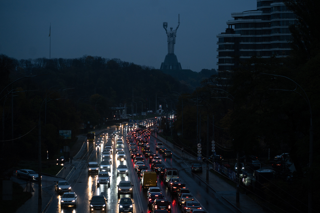 In a completely dark city, only car headlights are visible