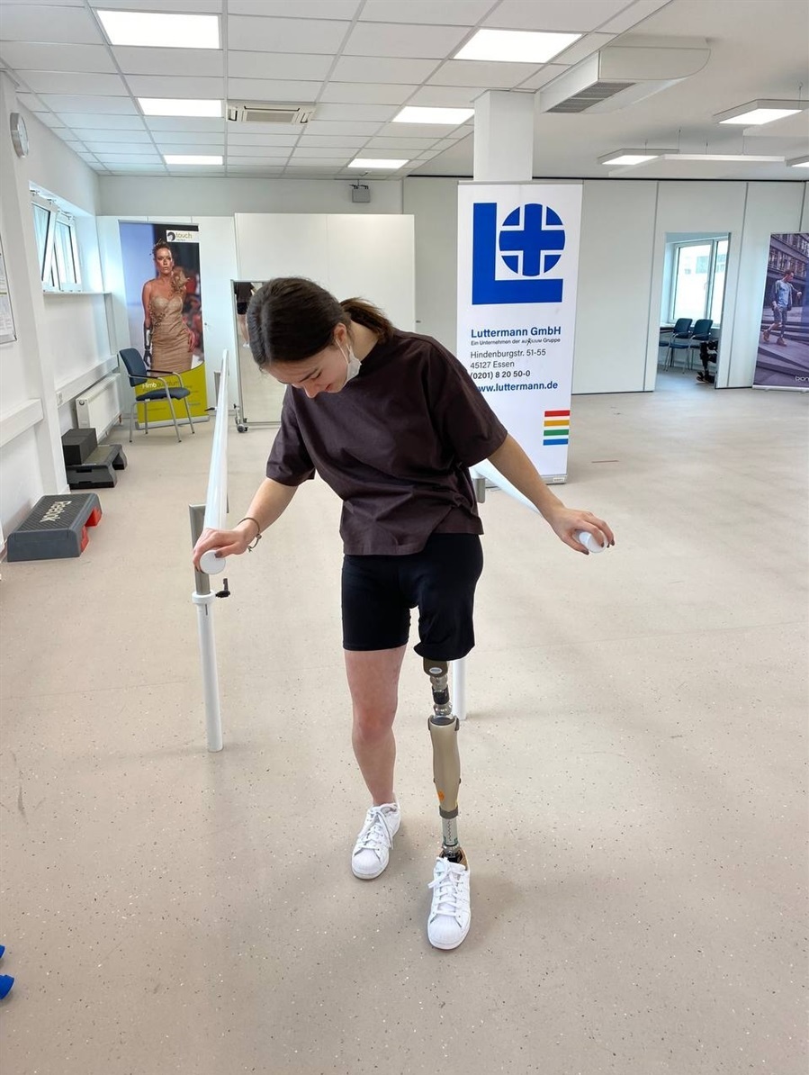 A girl with a prosthetic leg in a rehabilitation room