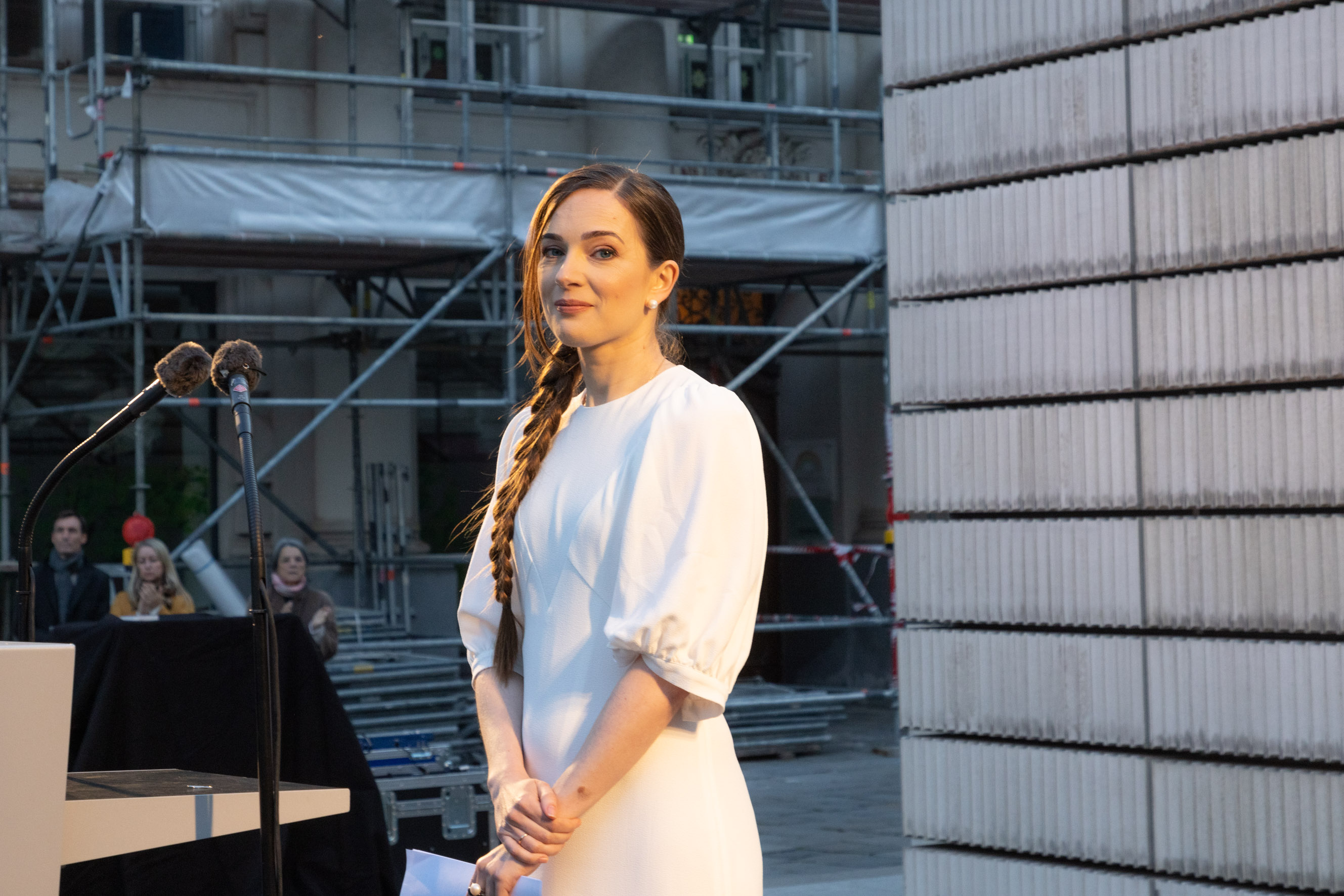 Oleksandra Matviichuk in a white dress looks into the camera