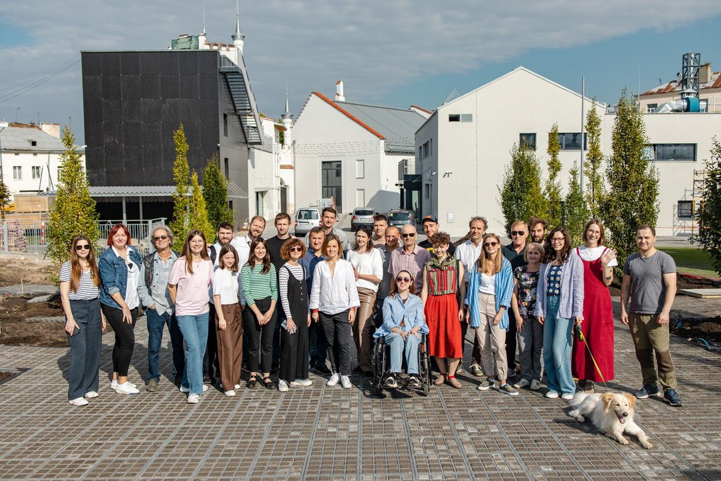 A group of people posing before a modern building