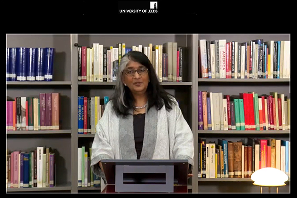 a screen grab of S Randeria standing wearing a black and white jacket giving the Bauman lecture in the IWM library