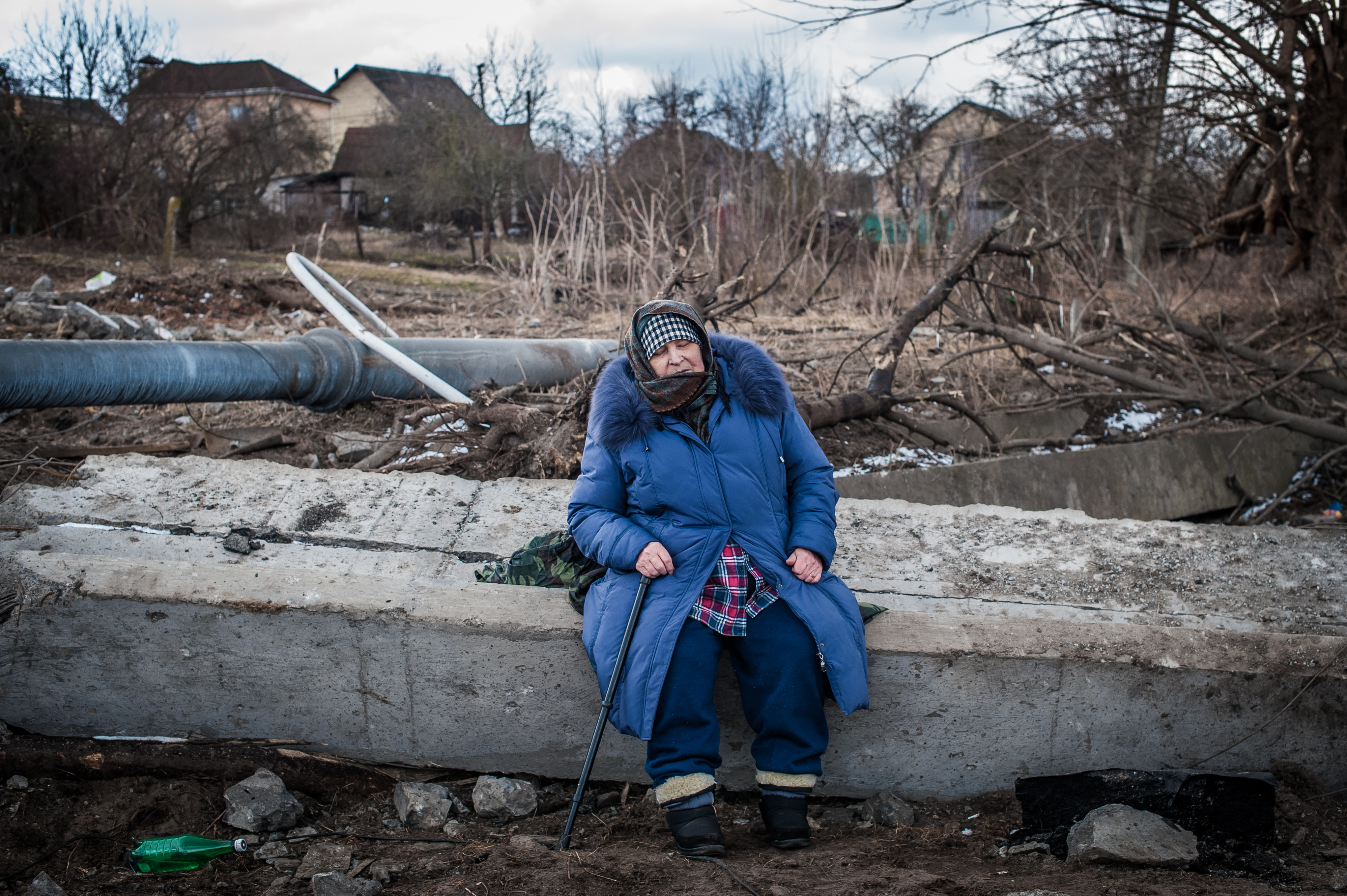 Eine alte Frau wartet auf die Hilfe von Freiwilligen in der Nähe der zerstörten Brücke während der Evakuierung von Irpin, Region Kyjiw (9. März 2022).