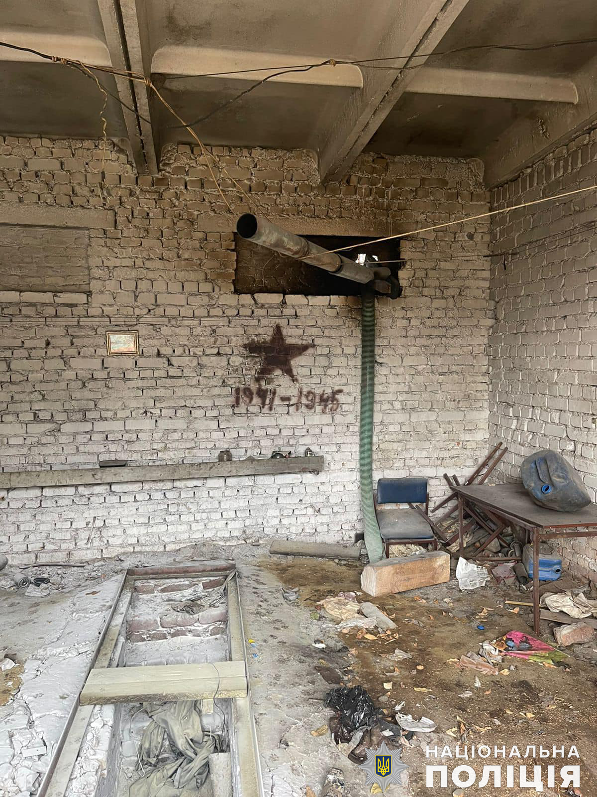 A dirty room with brick walls and graffiti