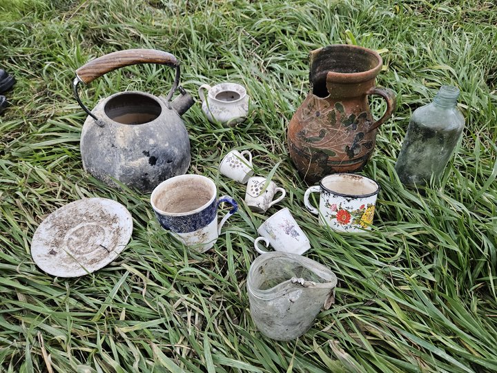 "Various items of pottery evacuated from war zone on grass"