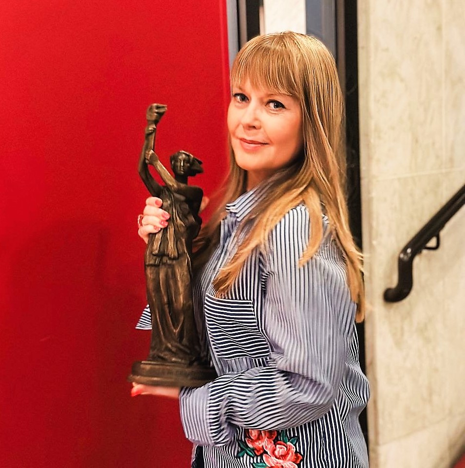 A woman holds statue in her hands