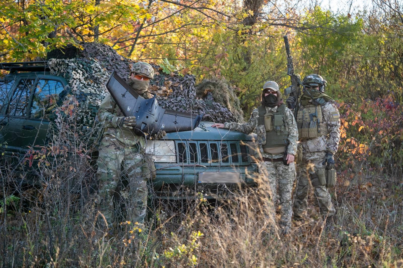 An air reconnaissance group in east Ukraine pose for a photo with an SUV supplied by Solidarity Collectives. 