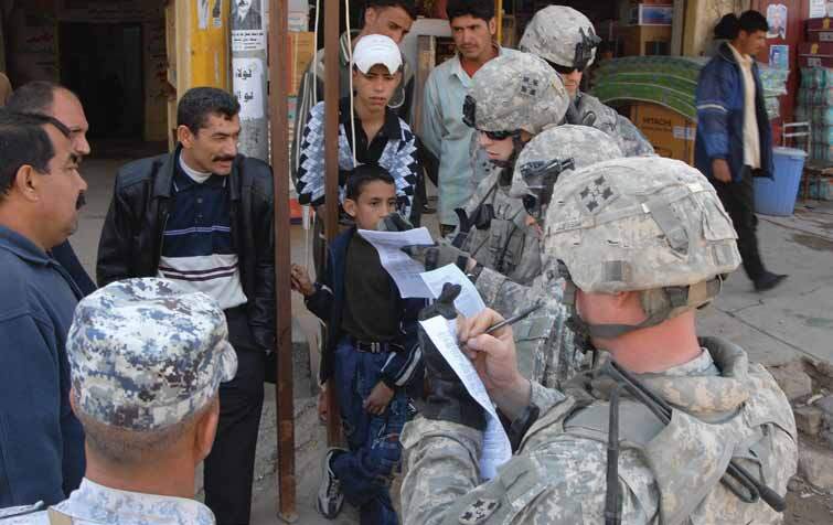 US-Soldaten führen auf einem Markt in Mahawil, Irak, eine Umfrage unter irakischen Wählern nach der Wahl durch.