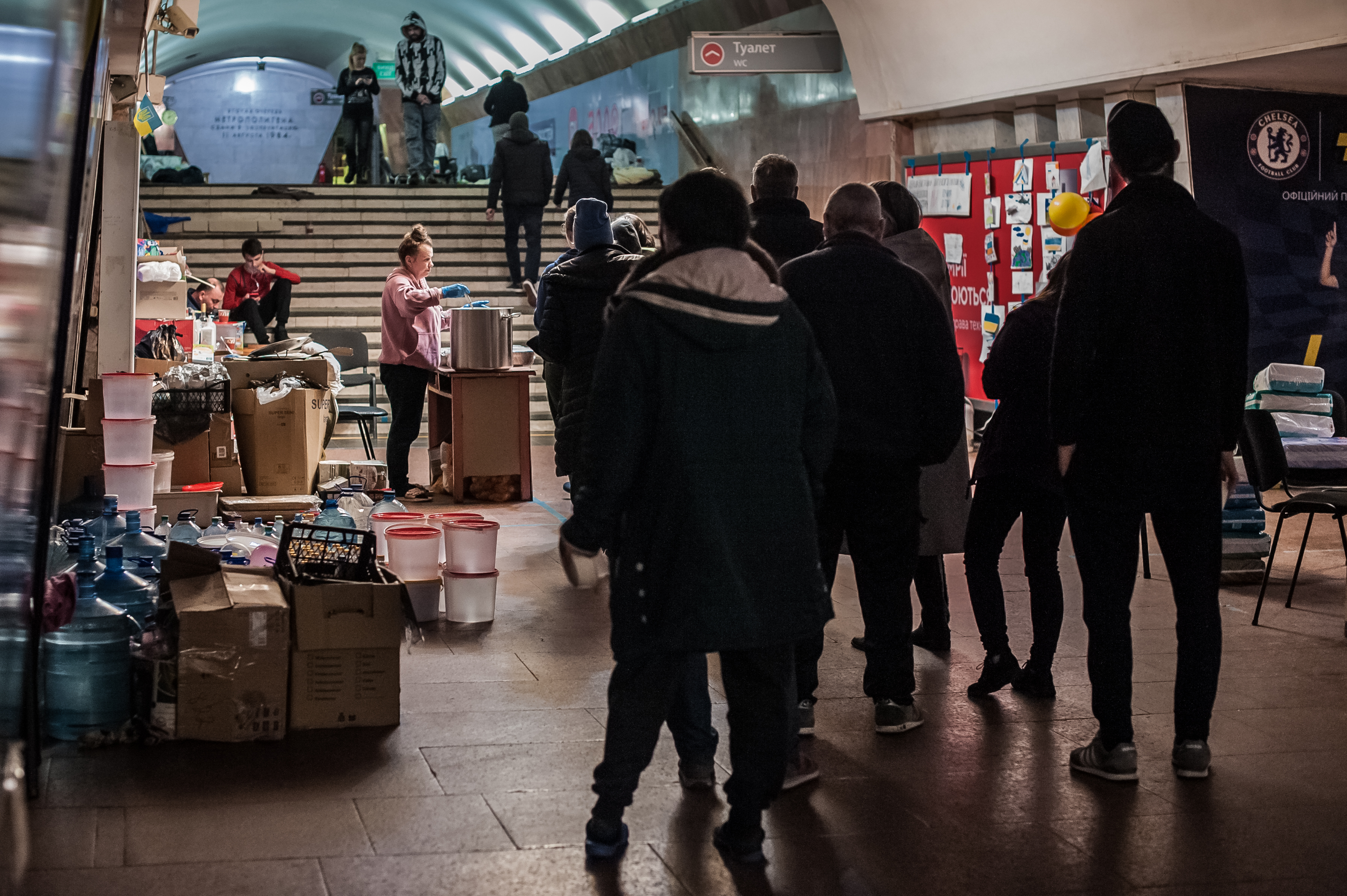 Residents of the Kharkiv metro station stand in the queue for a dinner prepared for them by volunteers, who live with them in the metro, on March 29 Credit: Alina Smutko