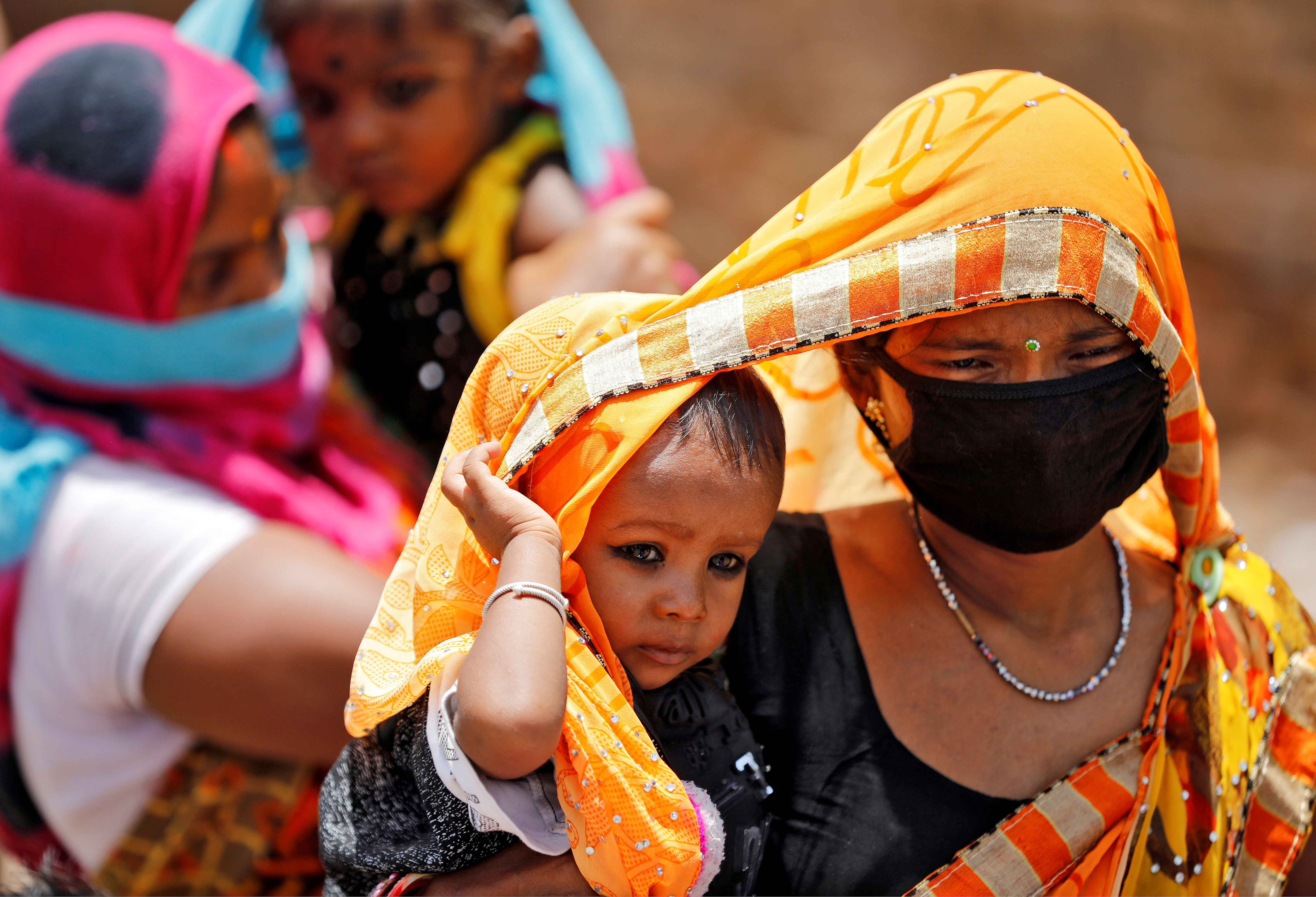 Migrant workers waiting to get on a bus to reach a railway station to board a train to their home state of eastern Bihar, during an extended lockdown in Ahmedabad, India, May 20, 2020.