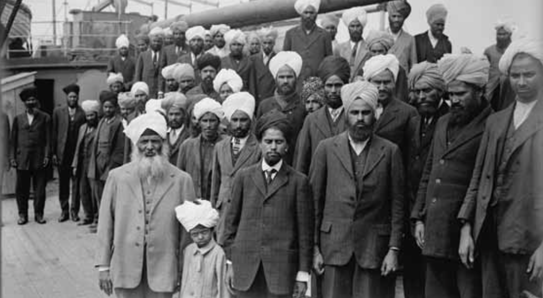 ikhs aboard Komagata Maru. Gurdit Singh wearing light colored suit, white beard on left, May 23 to July 23, 1914.