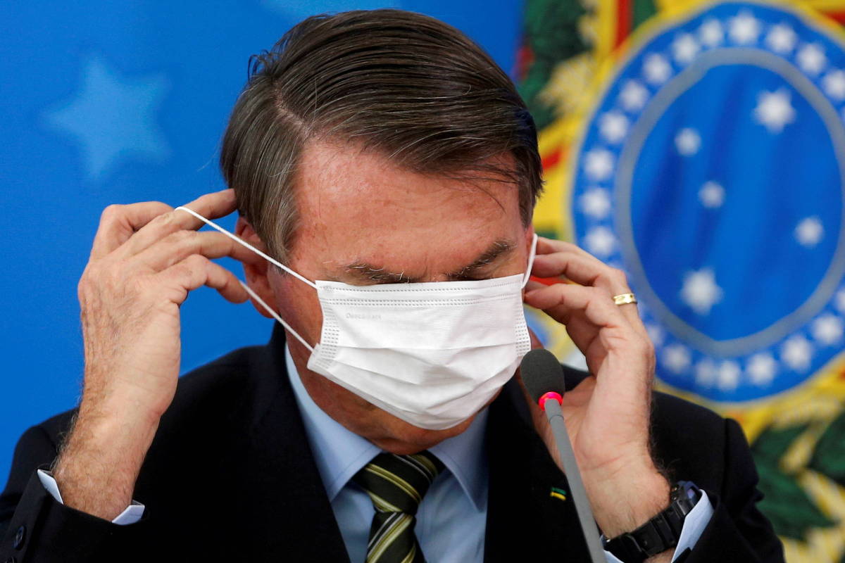 Brazil’s Jair Bolsonaro adjusts his protective face mask during a news conference to announce measures to curb the spread of the coronavirus disease (Covid-19) in Brasilia, Brazil March 18, 2020.