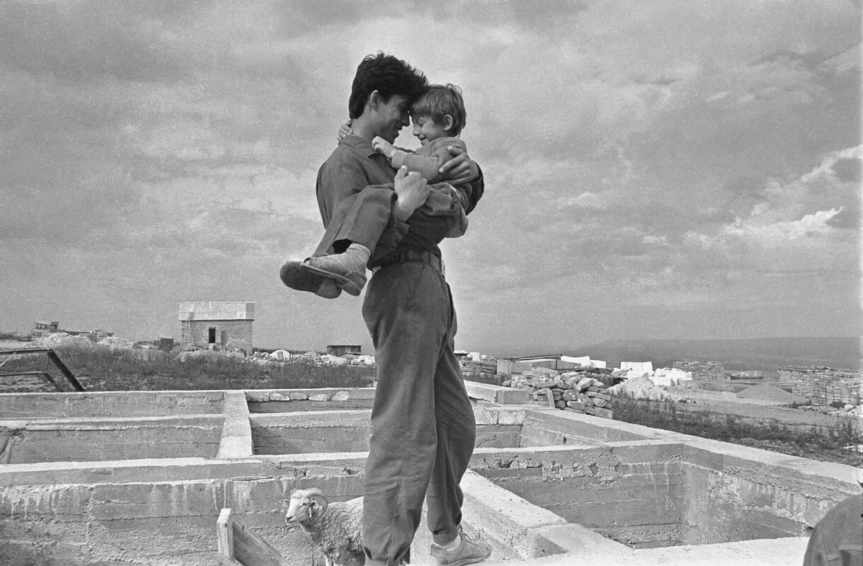 A black and white picture of a man holding a child 