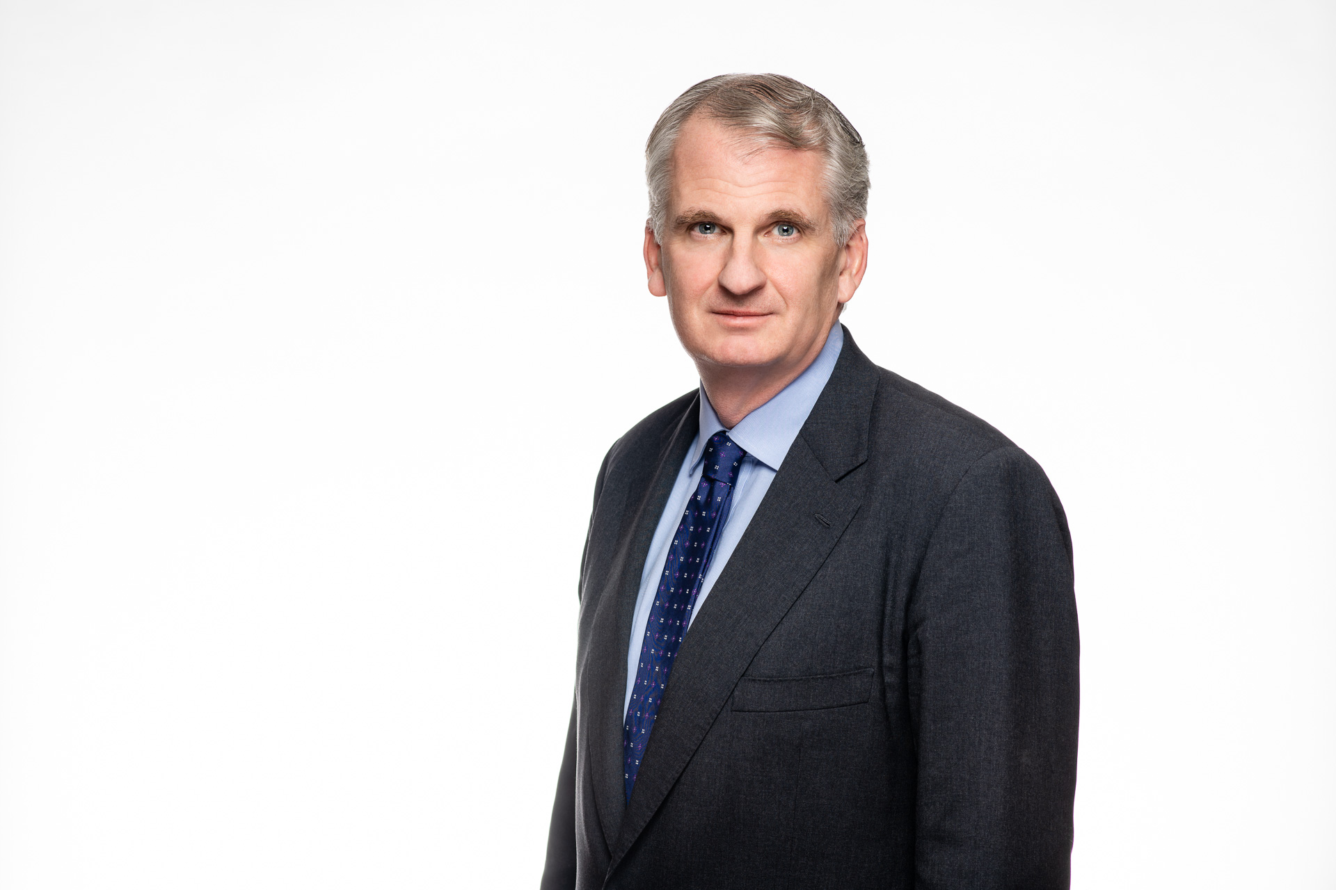 Portrait of Timothy Snyder, wearing a dark suit against a white background