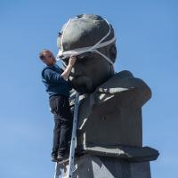 A man is bandaging a head of the monument