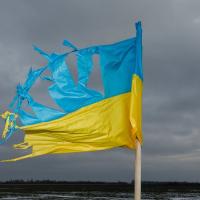 A picture of a torn-up Ukrainian flag in front of grey sky