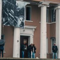 People in front of a building in liberated Kharkiv region