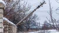 A telephone pole falling over in the snow