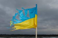 A picture of a torn-up Ukrainian flag in front of grey sky