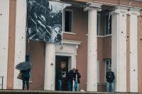People in front of a building in liberated Kharkiv region
