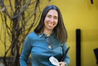 Picture of Merav Amir smiling in the IWM courtyard