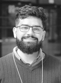 A black and white headshot of Pedro Perfeito Da Silva who has a beard and glasses